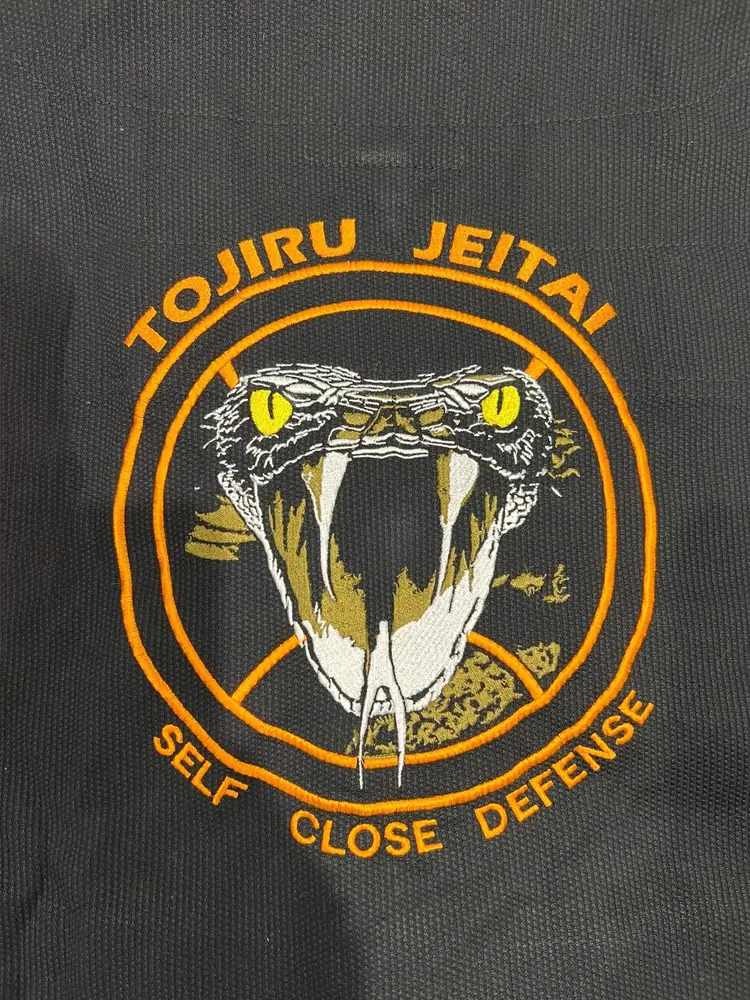 Logo Tojiru Jeitai ricamato sul retro di una giacca da combattimento